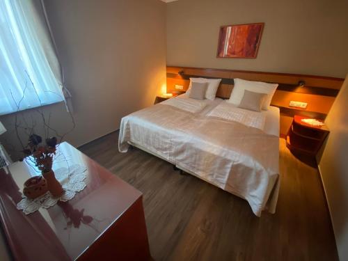 sypialnia z dużym białym łóżkiem i stołem w obiekcie Udoben apartma v Moravskih Toplicah - Terme Vivat w mieście Moravske Toplice