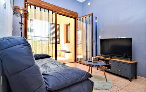 un salon avec un canapé et une télévision à écran plat dans l'établissement 2 Bedroom Amazing Apartment In Uzes, à Uzès