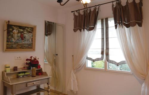 トゥーロンにあるAmazing Home In Toulon With 3 Bedrooms, Private Swimming Pool And Outdoor Swimming Poolの窓(カーテン、テーブル付)が備わる客室です。