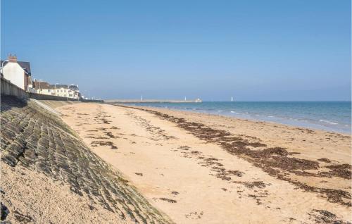 une plage de sable avec des empreintes sur le sable et l'océan dans l'établissement Amazing Apartment In Grandcamp Maisy, à Grandcamp-Maisy