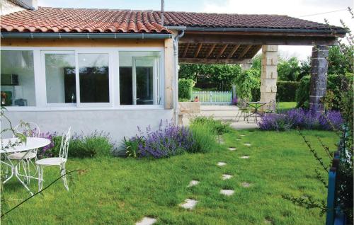 - un jardin avec une table, des chaises et des fleurs violettes dans l'établissement Lovely Home In St Fort Sur Gironde, à Saint-Romain-sur-Gironde
