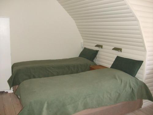 two green beds in a room with white walls at Nattely I Viborg By in Viborg
