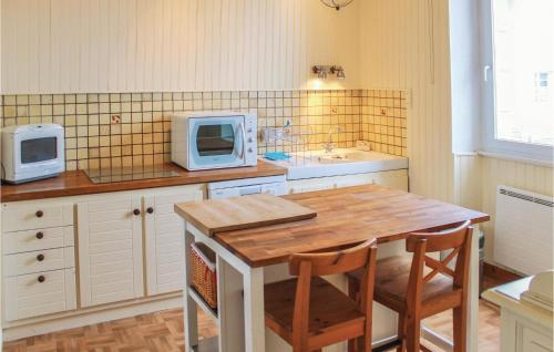 une cuisine avec une table en bois et un micro-ondes dans l'établissement Holiday Home R,du Creach-Mogueriec, à Sibiril