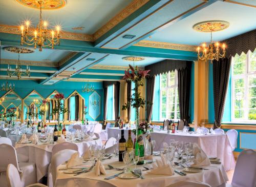 Best Western Abbots Barton Hotel في كانتربيري: غرفة طعام بطاولات بيضاء وكراسي وثريات