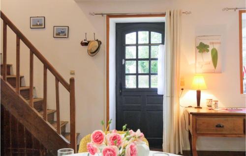 a room with a black door and a table with flowers at Nice Home In Auxais With Kitchenette in Auxais