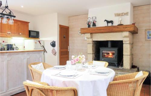 a dining room with a table and a fireplace at Nice Home In Auxais With Kitchenette in Auxais