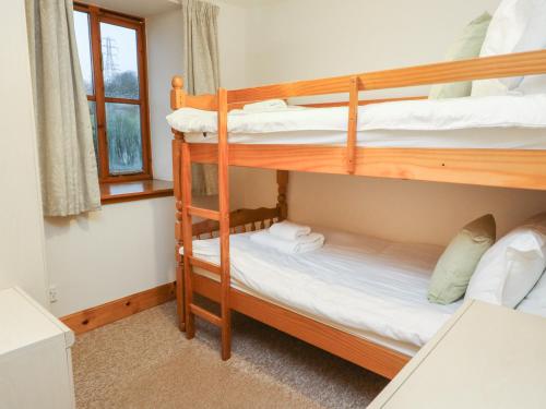 a bedroom with two bunk beds and a window at MacGregor in Pitlochry