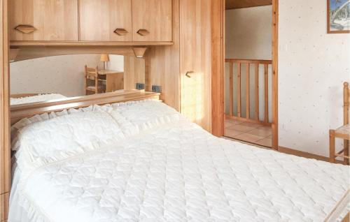 1 dormitorio con 1 cama blanca grande y armarios de madera en Amazing Home In La Faute Sur Mer With Kitchen, en La Faute-sur-Mer