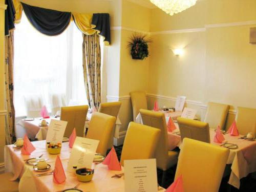 una sala da pranzo con tavoli e sedie con carte di Park View Guest House a York