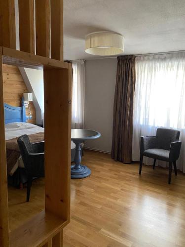 a bedroom with a bed and a table and chairs at Logis Hôtel Restaurant Au Cerf d'Or in Strasbourg