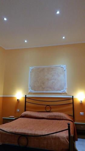 a bedroom with a bed with two lights on the wall at Hotel Gorizia in Catania