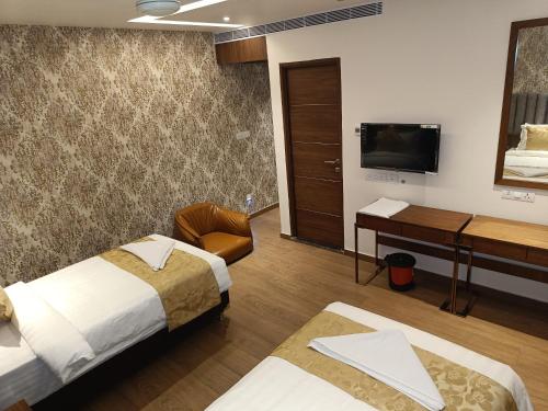 a hotel room with two beds and a desk and a television at The Kings Park Grand-Near US Consulate in Chennai