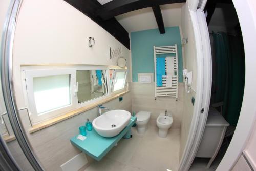 a bathroom with a sink and a toilet and a mirror at B&B I Fiori del Mare in Agropoli