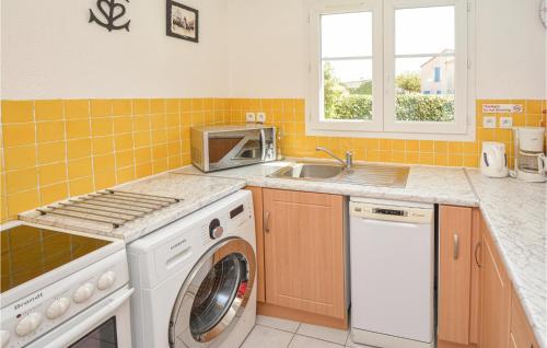 une cuisine avec une machine à laver et un évier dans l'établissement 3 Bedroom Awesome Home In Aigues-Mortes, à Aigues-Mortes