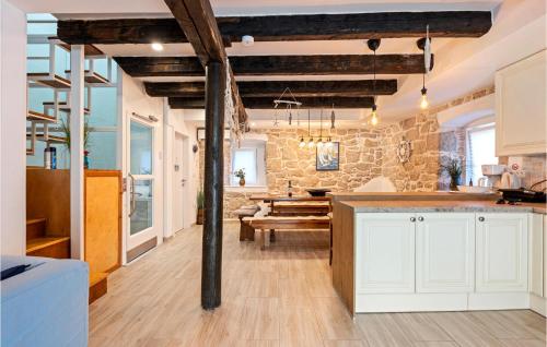 a kitchen with white cabinets and a stone wall at Holiday Home Murter 18 With Seaview in Murter