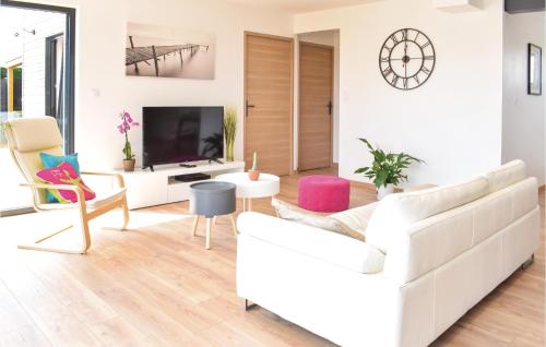 a living room with a white couch and a tv at Gorgeous Home In Créances With Wifi in Créances