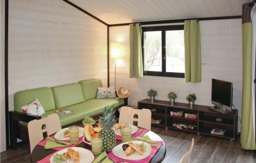 un salon avec un canapé vert et une table dans l'établissement Les Cottages Varois, à Solliès-Toucas