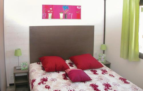 Solliès-ToucasにあるLes Cottages Varoisのベッド1台(上に赤い枕2つ付)