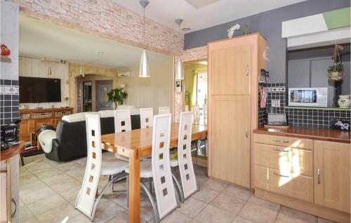 MaubecにあるBeautiful Home In Maubecの木製のテーブルと椅子のあるキッチンとダイニングルーム
