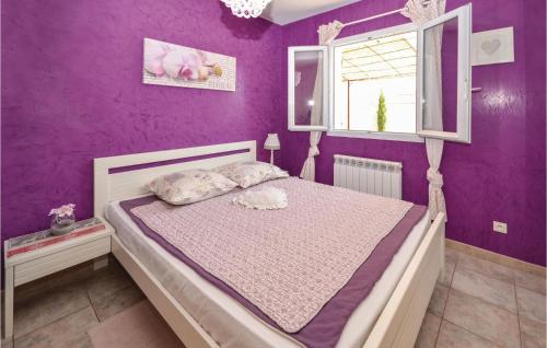 ein Schlafzimmer mit einem Bett mit lila Wänden und einem Fenster in der Unterkunft Nice Home In Maubec With Kitchen in Maubec