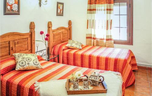 Villanueva del ReyにあるAwesome Home In Villanueva Del Rey With 4 Bedrooms And Outdoor Swimming Poolのベッドルーム1室(ベッド2台、食料品のトレイ付)