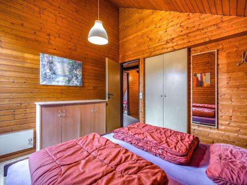 two beds in a room with wooden walls at Rustic holiday home in the Hochsauerland with balcony at the edge of the forest in Schmallenberg