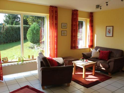 StrotzbüschにあるHouse with interior and garden in Volcanic Eifelのリビングルーム(ソファ、テーブル付)、窓が備わります。