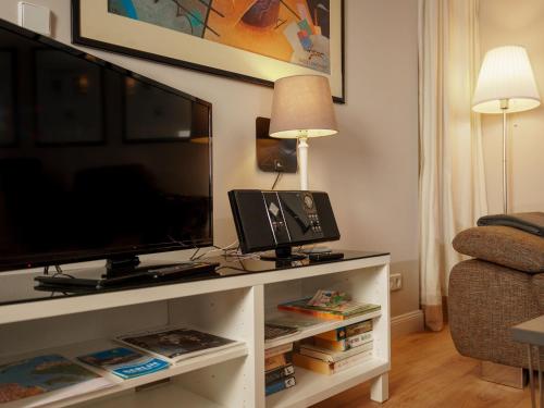uma sala de estar com uma televisão de ecrã plano num centro de entretenimento em Striking Apartment near Lake in Wannsee em Berlim