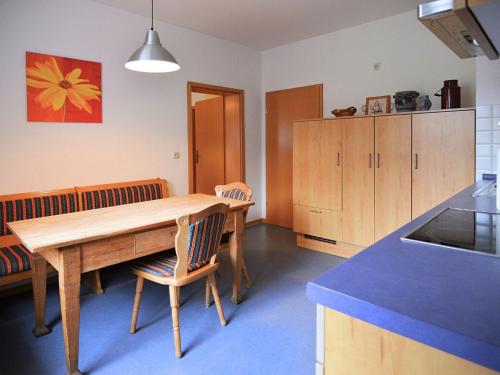 a kitchen with a wooden table and some chairs at Apartment with private terrace in H ddingen in Bad Wildungen