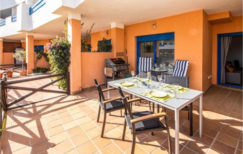 een terras met een tafel, stoelen en een grill bij 2 Bedroom Amazing Apartment In Manilva in Manilva