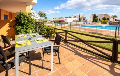 een tafel en stoelen op een patio met uitzicht op een zwembad bij 2 Bedroom Amazing Apartment In Manilva in Manilva
