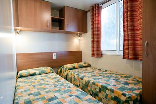 a hotel room with two beds and a window at Camping Europa in Capoliveri