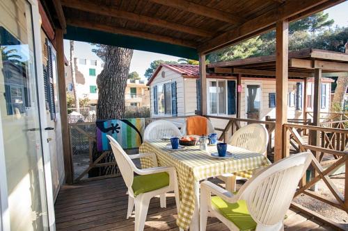 a table and chairs on a wooden deck with a table and chairs at Camping Europa in Capoliveri