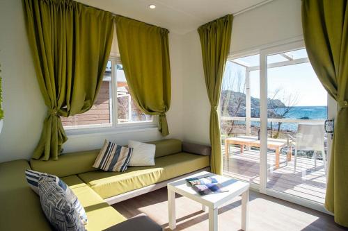 a living room with a couch and a large window at Camping Europa in Capoliveri