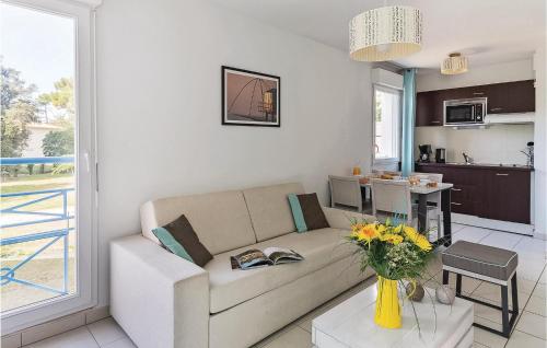 un salon avec un canapé et une cuisine dans l'établissement Les Carrelets, à Saint-Palais-sur-Mer