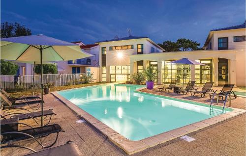 une piscine avec chaises et parasols devant une maison dans l'établissement Les Carrelets, à Saint-Palais-sur-Mer