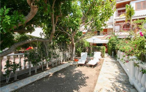 a patio with two lounge chairs and a tree at 5 Bedroom Nice Home In Santa Pola in Santa Pola