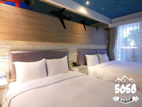 two beds in a hotel room with two beds sidx sidx sidx at R8 Eco Hotel in Kaohsiung