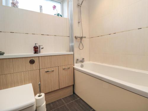 a bathroom with a tub and a toilet and a sink at Number Six in Burniston
