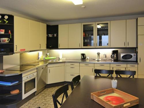 a kitchen with white cabinets and a table with chairs at Chic Holiday Home in Liesen with Garden in Hallenberg