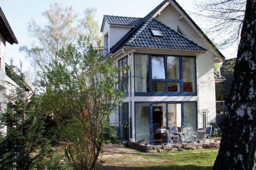 een blauw-wit huis met een tafel en stoelen bij Luxurious Apartment in Sch now with Sauna in Bernau bei Berlin