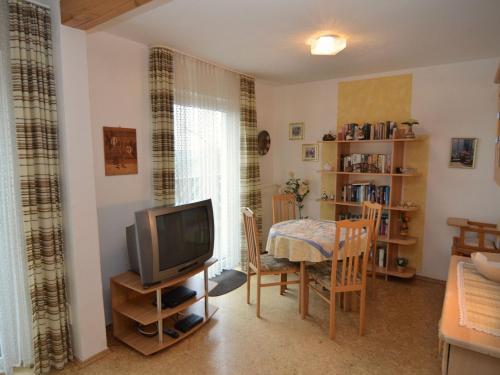 uma sala de estar com uma televisão e uma mesa de jantar em Nice holiday home near ski area em Medebach