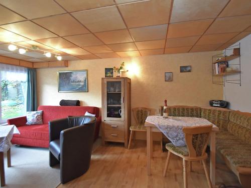 a living room with a red couch and a table at Idyllic holiday home in Neinstedt near forest in Thale