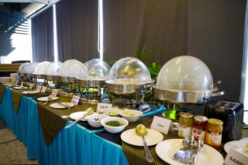 a buffet line with food in glass domes and dishes at Trivelles Executive Suites Islamabad in Islamabad
