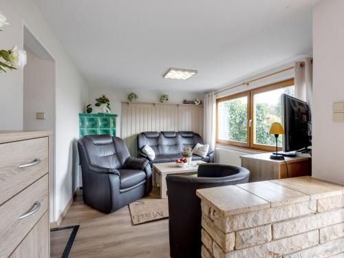 a living room with leather furniture and a tv at Holiday home in the Thuringian Forest in Wutha-Farnroda