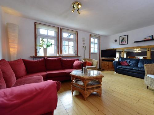 sala de estar con sofá rojo y mesa en Cozy holiday home with WiFi in Hochsauerland, en Elpe