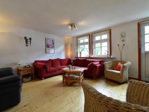 ElpeにあるCozy holiday home with WiFi in Hochsauerlandのリビングルーム(赤いソファ、椅子付)