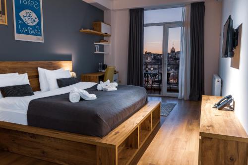 a bedroom with a bed and a view of a city at Reed Hotel Tbilisi in Tbilisi City