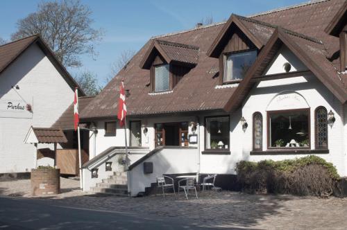 a white building with a brown roof at Purhus Kro in Fårup