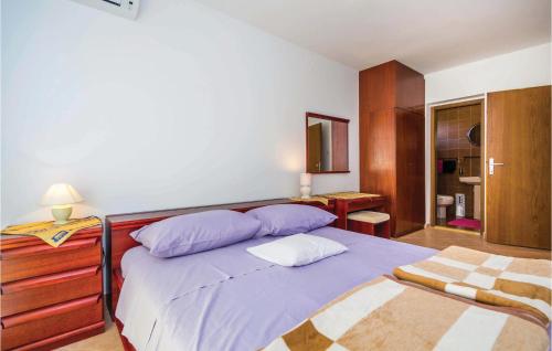 una camera da letto con un letto con lenzuola viola e un comò di 3 Bedroom Nice Apartment In Barbat a Barbat na Rabu